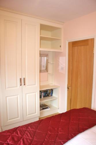 a bedroom with a bed and a white cabinet at Ard na Carraige, Ventry Holiday Home in Dingle