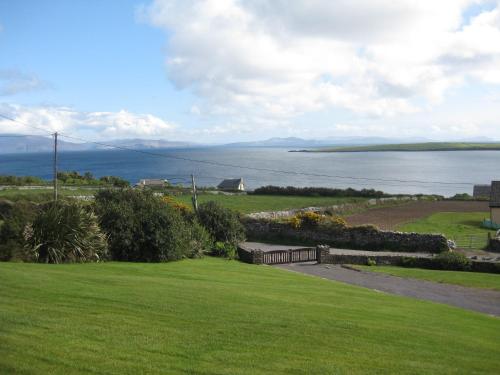 a view of the ocean from a park with a bench at Ard na Carraige, Ventry Holiday Home in Dingle