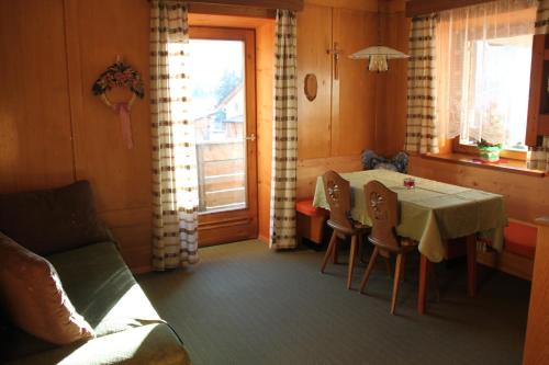 una sala da pranzo con tavolo, sedie e finestra di CIADIN APPART. a Badia