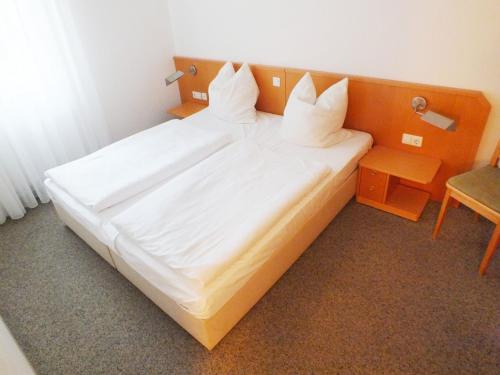 a large white bed in a small room at Ferienwohnung Möwe mit Balkon und einem Strandkorb im Sommer in Zempin