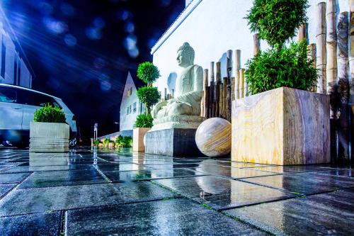 a statue on the side of a building in the rain at Naam Hotel & Apartments Frankfurt City-Messe Airport in Frankfurt