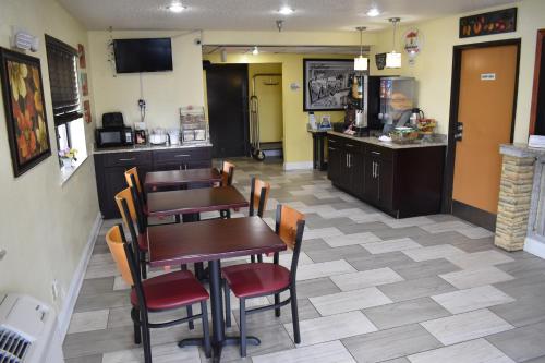 a restaurant with a table and chairs and a kitchen at Super 8 by Wyndham Newport News/Jefferson Ave. in Newport News