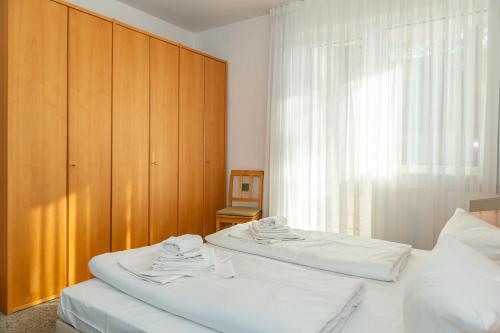 ツェンピンにあるApartment Arielleのベッドルーム1室(ベッド2台、木製キャビネット付)