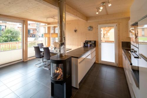 a kitchen with a fireplace in the middle of a room at Aron Chalet Kreischberg 10A in Sankt Lorenzen ob Murau