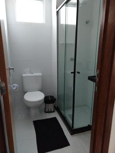 a bathroom with a toilet and a glass shower at Essencial Manaíra in João Pessoa