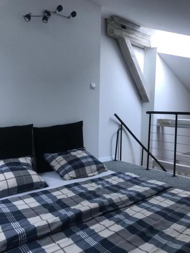 a bed with two pillows on it in a room at Klimatyczny apartament przy bocheńskim Rynku. in Bochnia