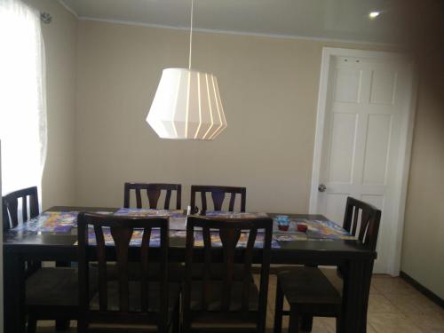 a dining room table with chairs and a chandelier at Casa Chayito in Santa María