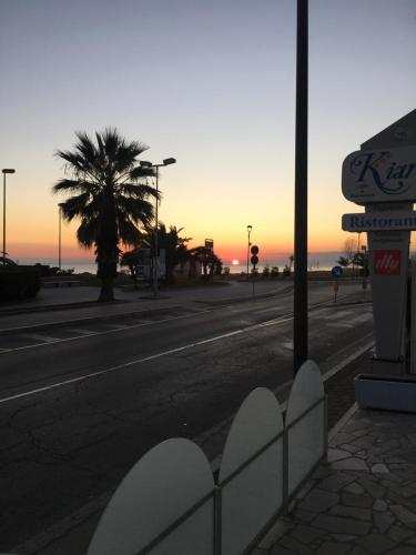 an empty street with a palm tree and a gas station at Kiara Residence in Giulianova