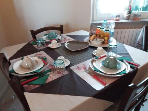 a dining room table with plates and utensils on it at Locanda 130 in Fonni