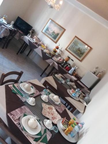 a dining room with a table with chairs and a tableablish at Locanda 130 in Fonni