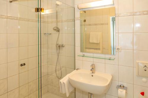 a white bathroom with a sink and a shower at Apartment Astra mit 2 Balkone in Zempin