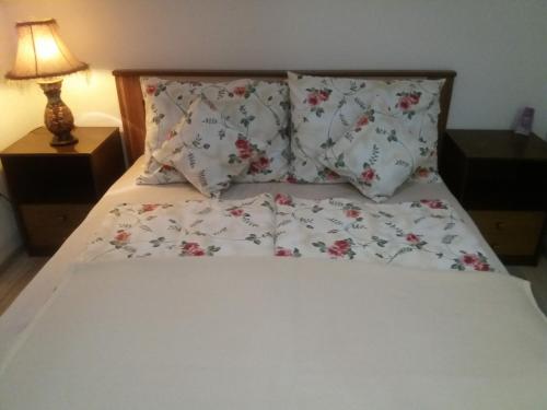 a bed with white sheets and pillows and a lamp at Edo in Visoko