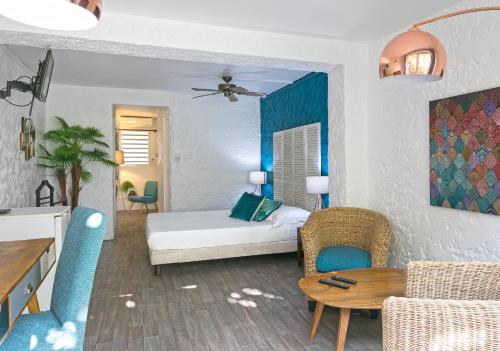 a living room with a bed and a table at Koho SXM - ex Hevea Hotel in Grand Case