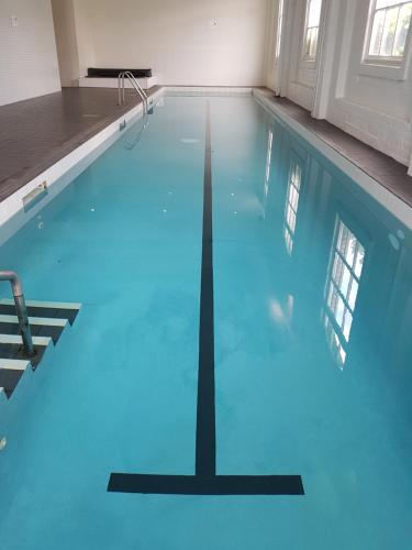 a swimming pool with blue water in a building at Downtown Townhouse Special in Auckland