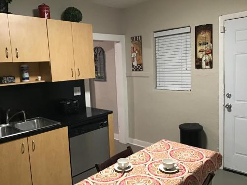 a small kitchen with a table and a sink at Modern 3/1 house close to Beaches and Midtown in Miami