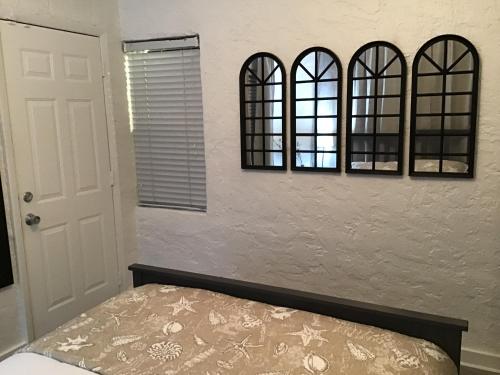 a bedroom with three mirrors above a bed at Modern 3/1 house close to Beaches and Midtown in Miami