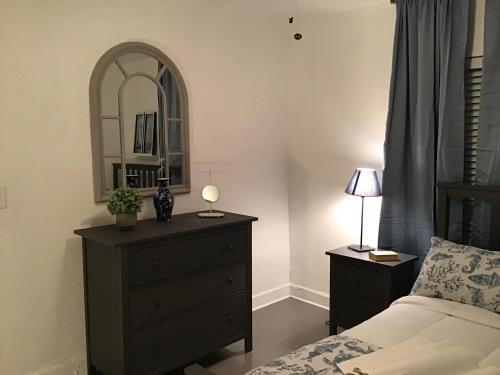 a bedroom with a bed and a dresser with a mirror at Modern 3/1 house close to Beaches and Midtown in Miami