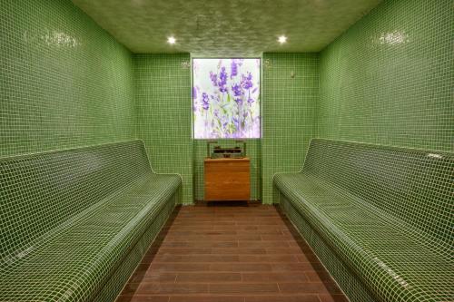 a green room with two benches and a window at Grand Hotel Velingrad in Velingrad