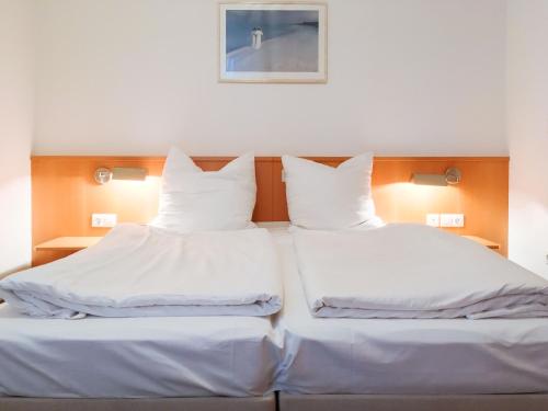 岑平的住宿－Apartment Fridolin，配有2张床的带白色床单和枕头的客房
