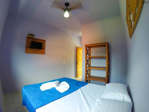 um quarto com uma cama com duas toalhas em POUSADA VIBE em Ubatuba