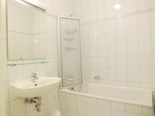 ツェンピンにあるApartment Lotteの白いタイル張りのバスルーム(シンク、バスタブ付)