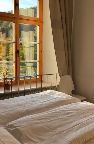 a bedroom with a bed and a large window at Gästehaus der Abtei Sayn in Bendorf