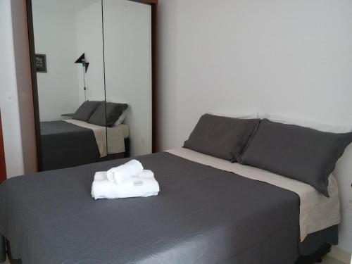 a bedroom with a bed with two folded towels on it at NOVO EDIFICIO VIENA - ATRAS do PRAIA CENTER in Guarapari