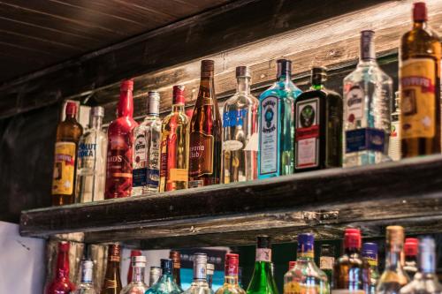 a bunch of bottles of alcohol on a shelf at RocaMar Hostel Boutique in Punta del Este