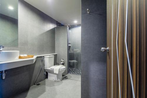 a bathroom with a toilet and a sink and a shower at Atelier Suites in Bangkok