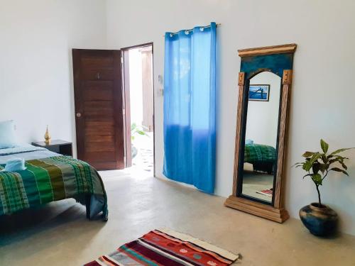 1 dormitorio con espejo, cama y espejo en Riad Masaya, en General Luna