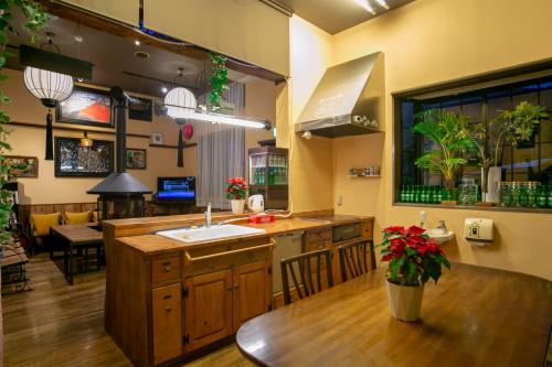 a kitchen with a sink and a table with a dining room at Yufuin Tabinokura in Yufuin