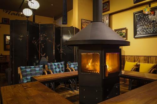 a fireplace in a restaurant with a table and chairs at Yufuin Tabinokura in Yufuin