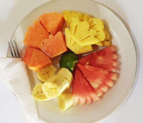 a white plate with a bunch of fruit on it at Arsa Homestay & Spa in Ubud