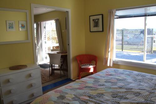 a bedroom with a bed and a dresser and a window at Laughing Fish Studio in Mapua