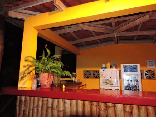 a kitchen with a red counter and a yellow wall at Buena Onda Backpackers in San Juan del Sur