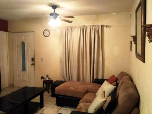 sala de estar con sofá y ventilador de techo en Casa Gamboa, en Ensenada