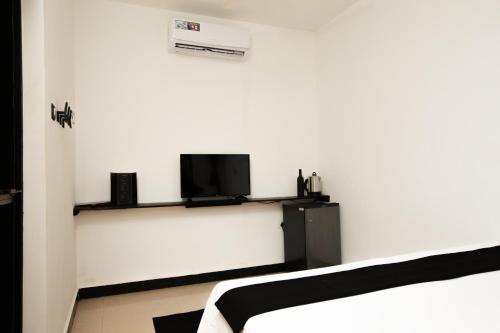 a room with two beds and a tv on a wall at Crystall Goa, Onyx Edition in Palolem