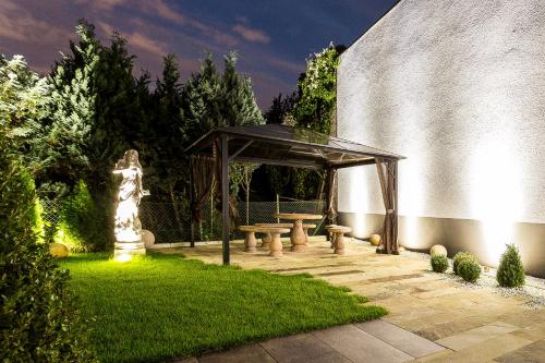 a gazebo with a picnic table in a garden at Naam Hotel & Apartments Frankfurt City-Messe Airport in Frankfurt