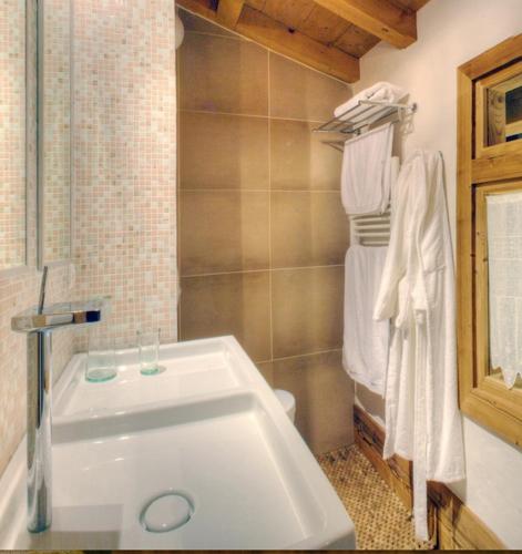 La salle de bains est pourvue d'un lavabo blanc et de serviettes. dans l'établissement CHALET CHAM'ROCK, aux Houches