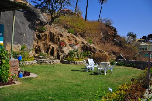 two chairs and a table in a yard at Hotel Oasis in Mount Ābu