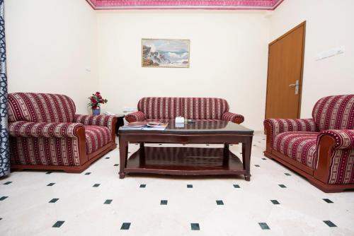 a living room with two chairs and a coffee table at Al Bahjah Hotel in Seeb