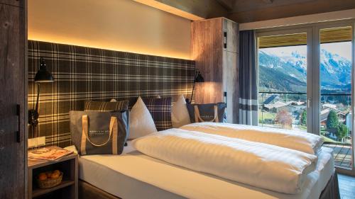 a bedroom with a bed with a view of a mountain at Mountain Spa Residences in Sankt Anton am Arlberg