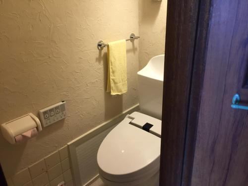 a bathroom with a white toilet and a towel at Guest house daisho oshiro asobi in Matsue