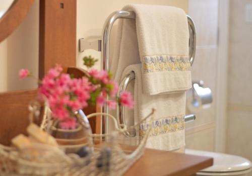 a bathroom sink with a basket of flowers and towels at Villa Te Soro Bed and breakfast in Auckland