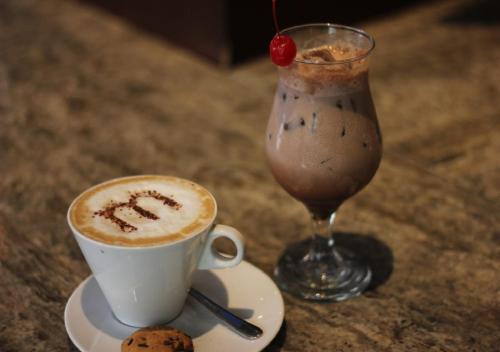 a cup of coffee and a drink on a table at Midtown Hotel Surabaya in Surabaya