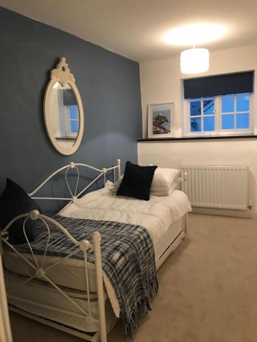 a bedroom with a bed with a mirror on the wall at York House in Conwy
