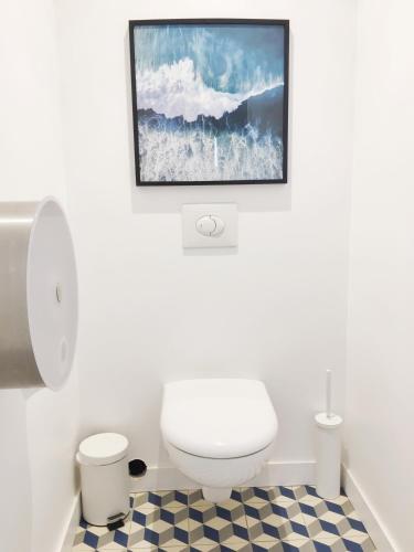 une salle de bain avec toilettes et un tableau au mur dans l'établissement Villa Hyper Centre, à Arcachon