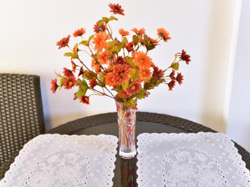 a vase of flowers sitting on top of a table at Anahaw Apartments Whitebeach in Boracay