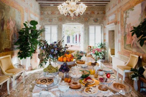 a table with many plates of food on it at I giardini segreti di Villa Marcello Marinelli in Cison di Valmarino