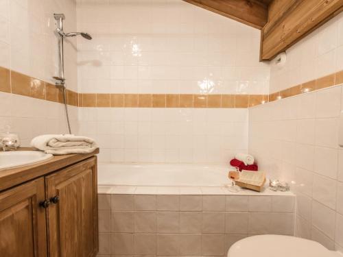 a bathroom with a tub and a toilet and a sink at Chalet Belvedere by Chalet Chardons in Tignes